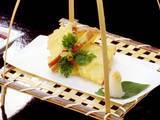 竹の様なもので編んだ器にりんごの天ぷらが盛りつけられている写真
